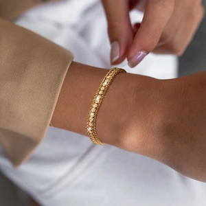 Gros plan sur le bracelet à trois rangs en acier doré 18K avec des pierres de zircon blanc