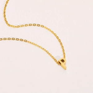Vista de detalle del collar de acero inoxidable dorado con un colgante de letra P 3D