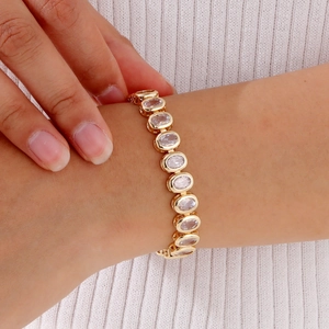 Detail shot of a gold-plated bracelet featuring oval cubic zirconia on a model's wrist