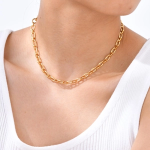 Detail of gold-plated chain necklace with spiral engraved links on model's neck
