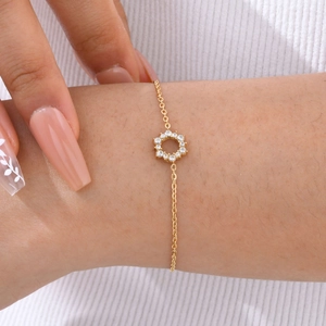 Elegant gold stainless steel sunflower bracelet with white zircons worn on wrist