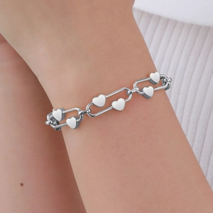 Détail du bracelet chaîne à maillons cœur argenté au poignet avec maillons ovales