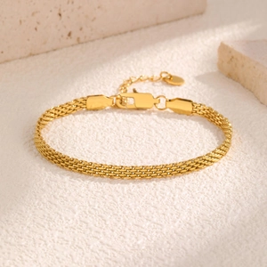 Detail of gold mesh woven bracelet showing fine metallic texture and secure lobster clasp