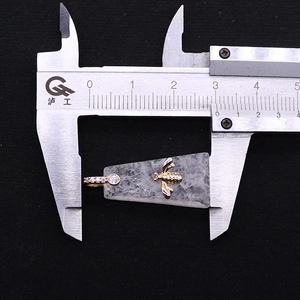 Detalle de colgante trapezoidal de piedra natural con 31 mm de ancho medido con calibre