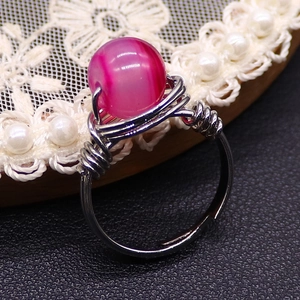 Detail of pink natural stone bead wrapped in silver wire on an adjustable ring