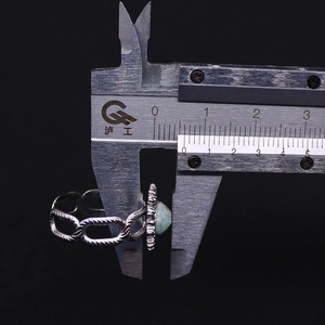 Measuring the 7mm natural stone width on a vintage silver link ring using a caliper