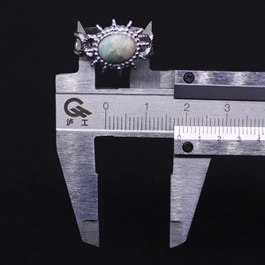 Detail view of vintage sunflower ring with natural green stone measured by a caliper