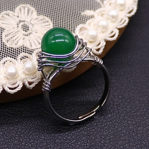 Macro shot of green bead handmade wire-wrapped stainless steel ring with adjustable band