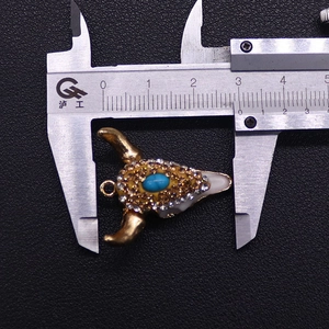 Nahaufnahme der Breite von 3,0 cm eines strassbesetzten Bullenkopf-Anhängers mit blauem Stein