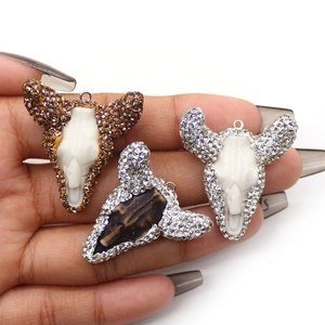 Drie bohemien stier schedel hangers van hars met strass randen en metalen ophanglussen