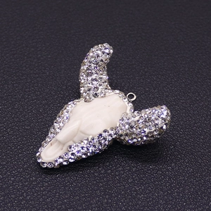 Macro-opname van een bull skull hars hanger met kristallen strass en metalen ring