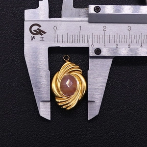 Macro view of a 15x23mm faceted rhodochrosite pendant with a gold pleated steel texture