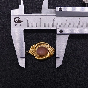Detailed measurement of the gold vintage pendant with pink stone using a digital caliper