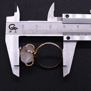 Macro shot measuring natural stone ring size with caliper on a black textured surface