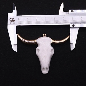 Detailed size measurement of resin bull skull pendant with gold horns on black background