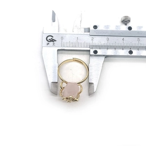 Caliper measuring the inner diameter of a gold bee ring with a pink natural stone
