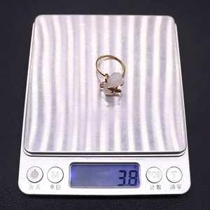 Detail showing hexagonal natural stone ring with bee design weighing 3.8 grams on a scale