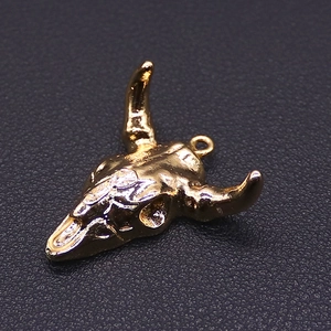 Macro shot of gold plated bull head pendant with intricate bohemian texture details