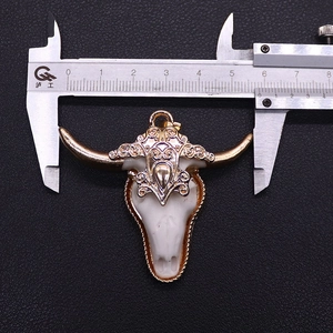 Detail van de hars stier schedel hanger met goud reliëf en afmetingen meting