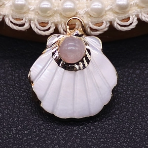 Detailed shell-shaped white pendant with gold plating and pink gemstone inlay detail