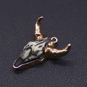 Macro view of a bohemian golden bull skull pendant with marble texture for DIY jewelry