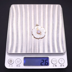 Detailed view of 2.6g freshwater shell flower pendant on a digital scale for weight check
