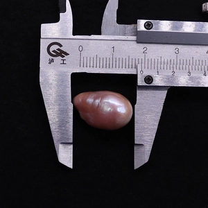 Misurazione di una perla barocca Edison viola irregolare da 15-16 mm con un calibro di precisione