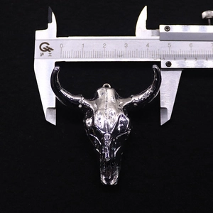 Vue détaillée d'un pendentif tête de taureau argenté de 4,8 cm mesuré avec un pied à coulisse