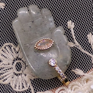 Detailed macro of a gold diamond ring and purple gemstone on a palm-shaped stone stand