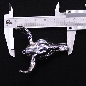 Détail du pendentif tête de taureau avec pied à coulisse mesurant sa largeur exacte