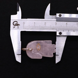 Detailed view of pink quartz Hamsa hand pendant with champagne gemstone and gold finish