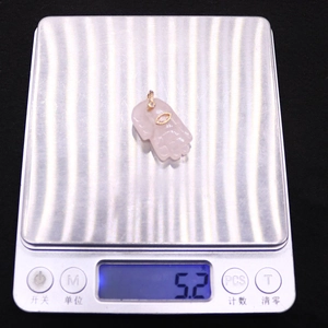 Detailed view of hand-shaped pink quartz pendant weighing 5.2g on digital scale