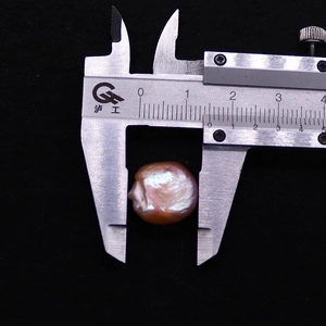 Makroaufnahme einer 18mm rosa Barock-Süßwasserperle mit einem Metall-Messschieber
