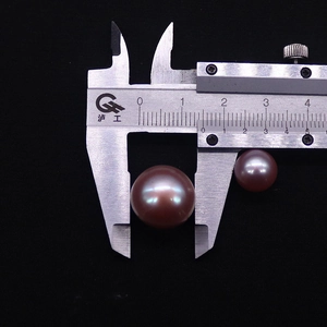 Misurazione dettagliata di perle Edison viola con calibro che mostra dimensioni 10mm e 18mm