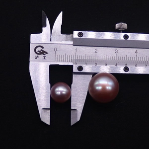 Vista di perle Edison viola da 10mm e 14mm misurate con un calibro su sfondo nero