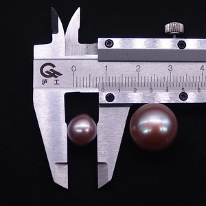 Macro di perle Edison viola misurate con un calibro per la precisione del diametro