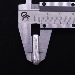 Dettaglio macro di perla barocca rettangolare misurata con un calibro, larghezza 5,5 mm
