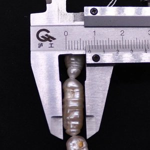 Calibro che misura una perla d'acqua dolce barocca da 28 mm con lucentezza metallica