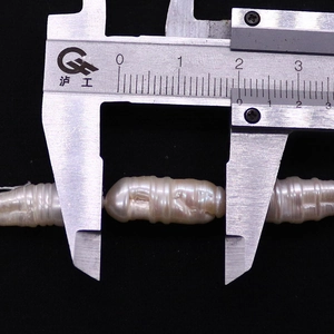 Dettaglio di una perla d'acqua dolce barocca da 21 mm misurata con un calibro di precisione