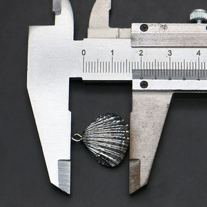 Détail macro d'un pendentif coquillage argenté montrant la texture et la largeur 1,6cm