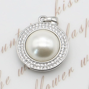 Pendentif perle halo argenté avec oxydes de zirconium posé sur une carte de style vintage