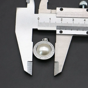 Vue détaillée du pendentif perle ronde de 18mm avec halo de strass au pied à coulisse