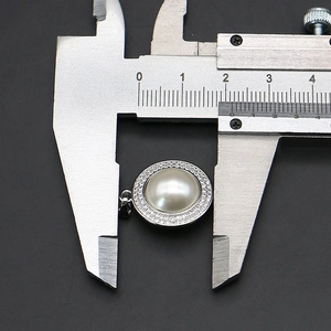 Vue macro du pendentif perle 18mm avec sertissage zircone et mesure au pied à coulisse
