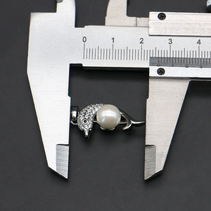 Detail van dolfijn hanger met witte parel gemeten met een schuifmaat voor de juiste maat