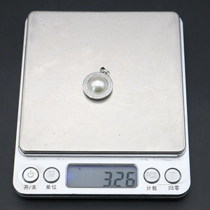 Détail macro du pendentif en argent avec perle et cristaux pesant 3,26g sur une balance
