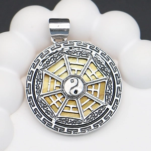 Macro shot of Yin Yang Bagua pendant with shell inlay and Greek Key pattern detailing