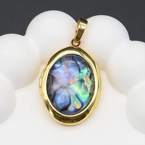 Vue détaillée du médaillon ovale doré avec incrustation d'abalone irisée et charnière