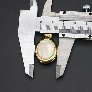 Vue détaillée d'un pendentif ovale en nacre mesuré avec un pied à coulisse 18mm