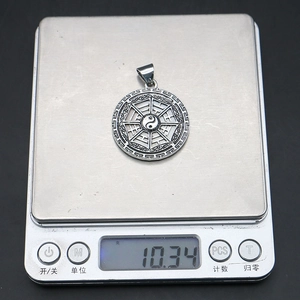 Detail shot of the Tai Chi Bagua pendant on a digital scale showing a weight of 10.34g