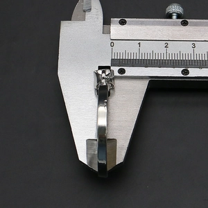 Measuring the thickness of the silver-plated tree of life pendant using a digital caliper